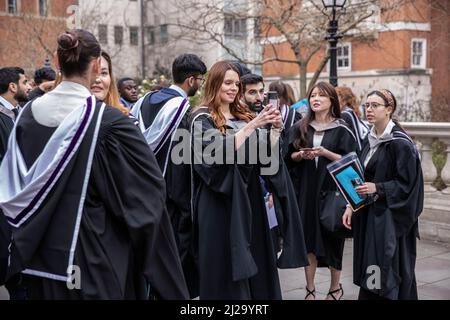 Absolventen des Imperial College London genießen die Atmosphäre außerhalb der Royal Albert Hall, obwohl Eltern oder Familienmitglieder nicht teilnehmen durften. Stockfoto