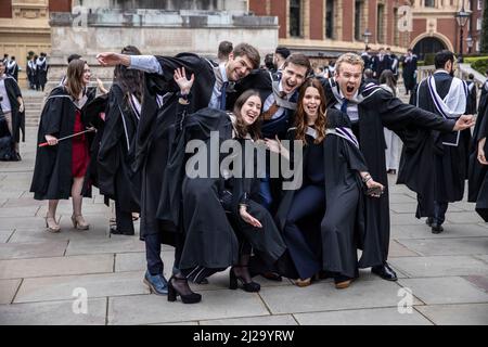 Absolventen des Imperial College London genießen die Atmosphäre außerhalb der Royal Albert Hall, obwohl Eltern oder Familienmitglieder nicht teilnehmen durften. Stockfoto