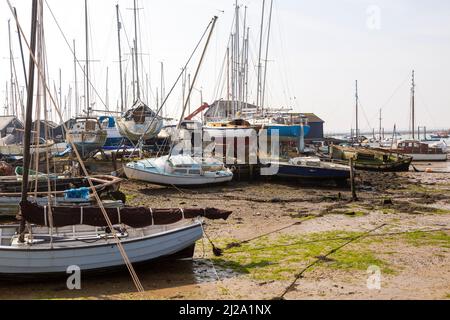 Boote in Bootswerft bei Ebbe, Flussmündung Blackwater, West Mersea, Mersea Island, Essex, England, Großbritannien Stockfoto