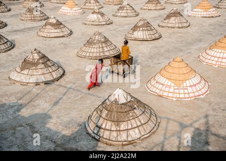 Brahmanbaria, Chittagong, Bangladesch. 31. März 2022. Kinder laufen und spielen zwischen Hunderten traditioneller Reismühlen aus Bambus.nach dem Kochen wird das Getreide von Arbeitern in Haufen gefegt und bis zu acht Stunden lang in Brahmanbaria, Bangladesch, getrocknet. Die Reismühlenarbeiter begannen ihre Arbeit von sehr früh morgens von 5 bis 2pm Uhr täglich. Nach der Mittagspause spielen die Kinder der Arbeiter ihre Nachmittagsspiele mit Freunden in diesem Reismühlenfeld. (Bild: © Mustasinur Rahman Alvi/ZUMA Press Wire) Bild: ZUMA Press, Inc./Alamy Live News Stockfoto