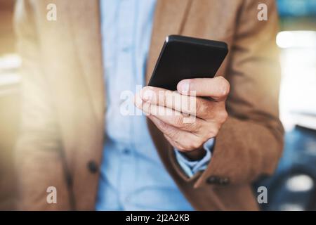 Herstellen der Android-Verbindung. Ausgeschnittene Aufnahme eines Geschäftsmannes mit einem Mobiltelefon. Stockfoto