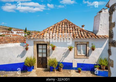 Fassade eines kleinen Steinhauses im mittelalterlichen Obidos, Portugal Stockfoto