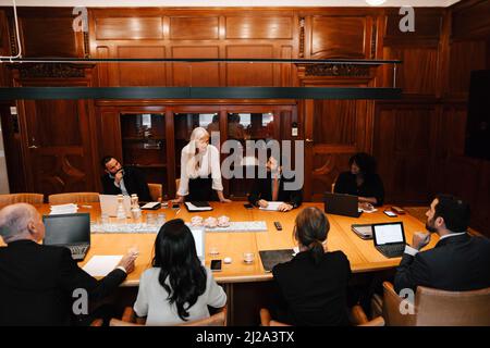 Reife Geschäftsfrau diskutieren mit Anwälten bei der Sitzung im Vorstandszimmer Stockfoto