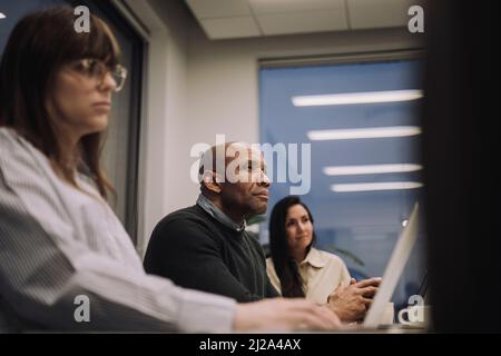 Mehrrassische männliche und weibliche Kollegen, die spät im Amt arbeiten Stockfoto