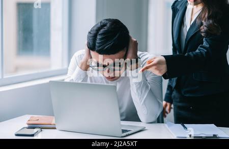 Zwei asiatische Kollegen streiten sich hitzig miteinander Stockfoto