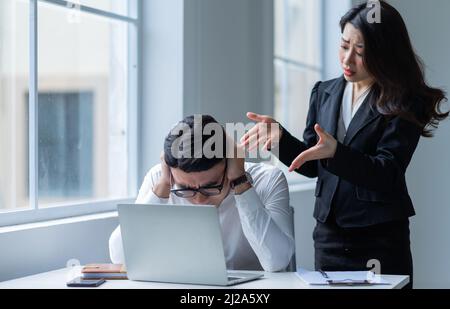 Zwei asiatische Kollegen streiten sich hitzig miteinander Stockfoto