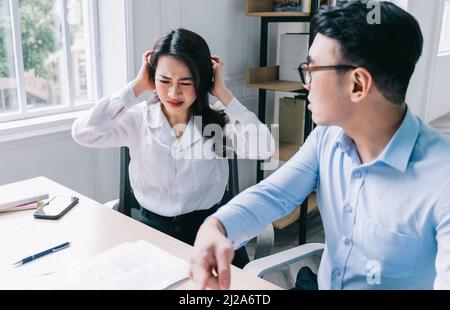 Zwei asiatische Kollegen streiten sich hitzig miteinander Stockfoto