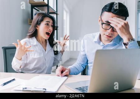 Zwei asiatische Kollegen streiten sich hitzig miteinander Stockfoto