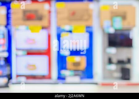 Eletronisches Kaufhaus mit verschwommenen Fernsehregalen im Hintergrund Stockfoto