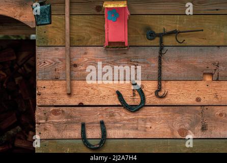 Retro Dorfwerkzeuge und Ausrüstung auf einer Holzwand aus Brettern Stockfoto
