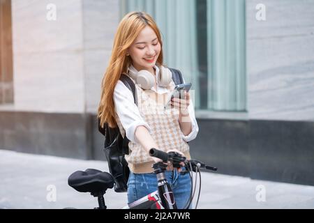 Junge asiatische Frau mit Fahrrad als Transportmittel Stockfoto