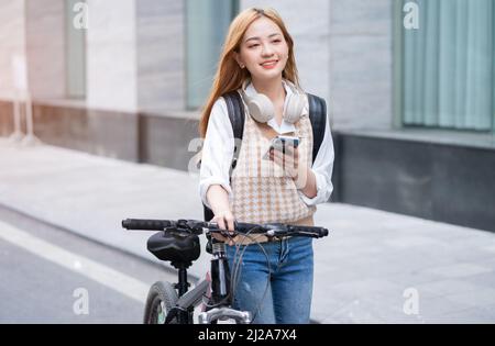 Junge asiatische Frau mit Fahrrad als Transportmittel Stockfoto