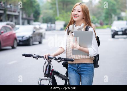 Junge asiatische Frau mit Fahrrad als Transportmittel Stockfoto