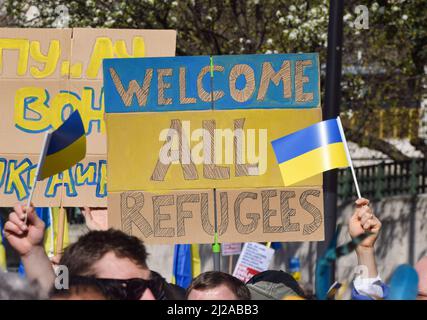 London, Großbritannien. 26.. März 2022. Ein Protestler in der Park Lane hält ein Schild „Welcome All Refugees“, während der Londoner marsch mit der Ukraine stattfindet. Tausende von Menschen marschierten aus Solidarität mit der Ukraine von der Park Lane zum Trafalgar Square, während Russland seinen Angriff fortsetzt. Stockfoto