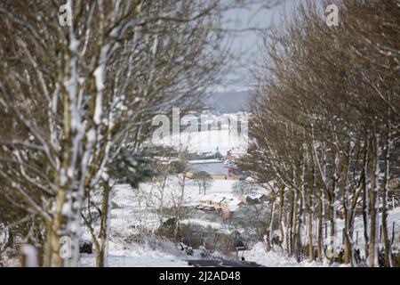 Queensbury, Bradford, West Yorkshire, Großbritannien. 31.. März 2022. Wetter in Großbritannien. Ein kalter, verschneiter Morgen in der West Yorkshire-Stadt Queensbury, in der Nähe von Bradford, England, Großbritannien. Queensbury ist ein großes Dorf im Metropolbezirk Bradford, West Yorkshire, England. Queensbury liegt an einem hohen Aussichtspunkt über Halifax, Clayton und Thornton und überblickt Bradford selbst und ist eine der höchsten Gemeinden in England. Kredit: Windmill Images/Alamy Live Nachrichten Stockfoto