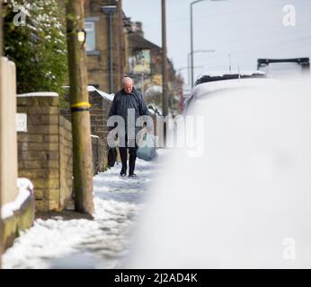 Queensbury, Bradford, West Yorkshire, Großbritannien. 31.. März 2022. Wetter in Großbritannien. Ein kalter, verschneiter Morgen in der West Yorkshire-Stadt Queensbury, in der Nähe von Bradford, England, Großbritannien. Queensbury ist ein großes Dorf im Metropolbezirk Bradford, West Yorkshire, England. Queensbury liegt an einem hohen Aussichtspunkt über Halifax, Clayton und Thornton und überblickt Bradford selbst und ist eine der höchsten Gemeinden in England. Kredit: Windmill Images/Alamy Live Nachrichten Stockfoto