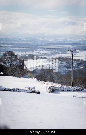 Queensbury, Bradford, West Yorkshire, Großbritannien. 31.. März 2022. Wetter in Großbritannien. Ein kalter, verschneiter Morgen in der West Yorkshire-Stadt Queensbury, in der Nähe von Bradford, England, Großbritannien. Queensbury ist ein großes Dorf im Metropolbezirk Bradford, West Yorkshire, England. Queensbury liegt an einem hohen Aussichtspunkt über Halifax, Clayton und Thornton und überblickt Bradford selbst und ist eine der höchsten Gemeinden in England. Kredit: Windmill Images/Alamy Live Nachrichten Stockfoto