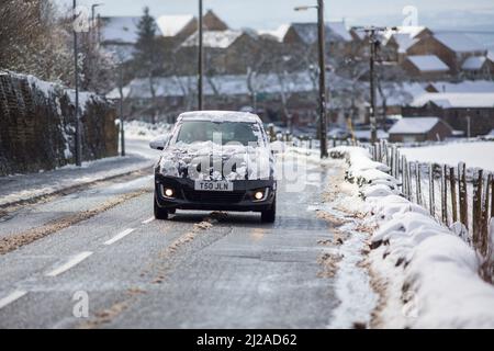 Queensbury, Bradford, West Yorkshire, Großbritannien. 31.. März 2022. Wetter in Großbritannien. Ein kalter, verschneiter Morgen in der West Yorkshire-Stadt Queensbury, in der Nähe von Bradford, England, Großbritannien. Queensbury ist ein großes Dorf im Metropolbezirk Bradford, West Yorkshire, England. Queensbury liegt an einem hohen Aussichtspunkt über Halifax, Clayton und Thornton und überblickt Bradford selbst und ist eine der höchsten Gemeinden in England. Kredit: Windmill Images/Alamy Live Nachrichten Stockfoto