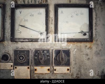 ONahaufnahme eines rostigen alten großen Voltmeters und Amperemeters. Stockfoto