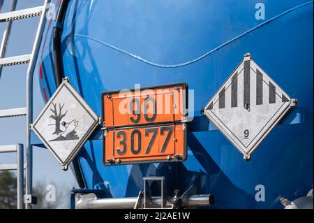 Verschiedene Gefahrgutschilder am Tank eines Tankwagens Stockfoto