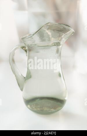 Sauberes Wasser im Glaskrug, Quellwasser in Rohrleitungen, Betrieb von Wasserfiltern Stockfoto