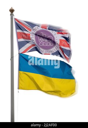 Die Platinum Jubilee Union Jack-Flagge, die auf einer Stange fliegt, zusammen mit der zweifarbigen Flagge der Ukrainischen Volksrepublik mit schlichtem, hellem Himmel dahinter Stockfoto