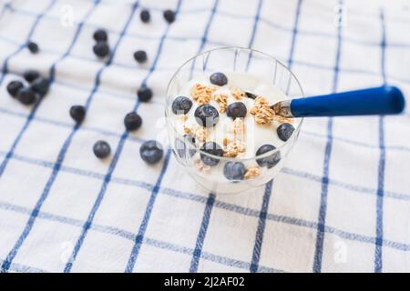 Joghurt mit Müsli und Heidelbeeren. Gesundes kalorienarmes Frühstück. Gesunde Blaubeeren mit natürlichem Joghurt und Haferflocken Stockfoto