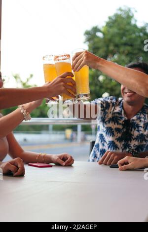 Junge Freunde trinken Bier und unterhalten sich an einer Bar Stockfoto