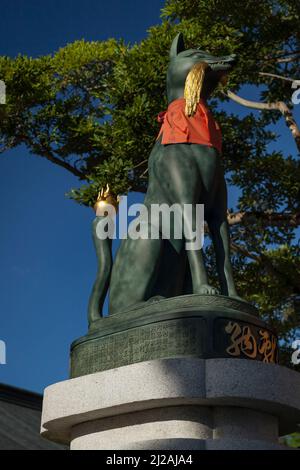 Vertikale Ansicht einer grünen Kitsune (Fuchs auf der Wache) Statue im Fushimi-Inari Taisha Shinto Schrein, Kyoto, Japan Stockfoto