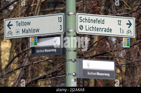 Blankenfelde Mahlow, Deutschland. 31. März 2022. Schilder entlang des Mauerwegs weisen Radfahrer in die Richtung zum Bahnübergang Lichtenrade. Mit einer neuen Eisenbahnbrücke des Dresdner Bahn-Bauprojekts in der Nähe des Dorfes Waldblick soll ab 2024 die bestehende Unterbrechung des Berliner Mauerwegs durch die Linien der S-Bahn und der Hauptbahn im ehemaligen Grenzstreifen zwischen Ost- und West-Berlin beseitigt werden. Dadurch werden auch lange Umwege für Fußgänger und Radfahrer vermieden. Quelle: Sören Sache/dpa-Zentralbild/ZB/dpa/Alamy Live News Stockfoto