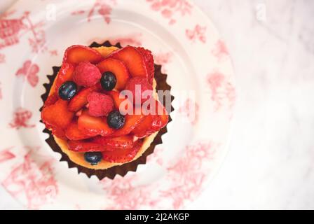Frische hausgemachte Obsttarte mit Erdbeere isoliert auf weißem Tisch, Blick von oben. Selektiver Fokus. Stockfoto