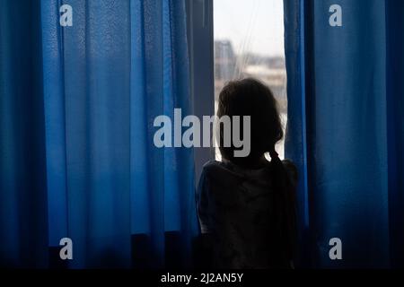 Wenig Trauriges Mädchen in der Nähe der Fenster. Missbrauch von Kindern Konzept Stockfoto