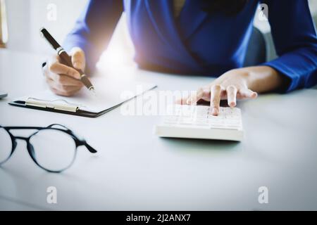 Buchhalter, Führungskräfte, Wirtschaftsprüfer, Ökonomen, asiatische Frauen aus der Wirtschaft verwenden Rechner, um Jahresabschlüsse und Investitionen zu berechnen Stockfoto