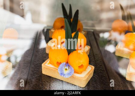 Käsekuchen mit Marian Pflaume Verkauf in den Kühlschränken im Café dekoriert. Stockfoto