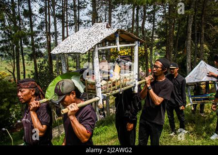 Lembang, Indonesien. 31. März 2022. Männer werden bei einer Prozession in Lembang mit einer Opfergabe von Produkten gesehen. Haschat lembur oder Nadar Tumbalan ist ein Ausdruck der Dankbarkeit und der Bitte, dass die Bewohner des Dorfes Buni Asih, Lembang, dem Allmächtigen Sicherheit, Wohlergehen und Gesundheit geben. Kredit: SOPA Images Limited/Alamy Live Nachrichten Stockfoto