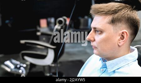 Besuch im Friseurladen. Stilvoller Mann macht modische Frisur. Friseur, Friseur, Stylistin mit Schere, Kammschnitt, dryer.Combing Haare. Kunde, Kunde Stockfoto