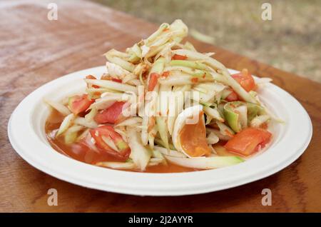 Thailändische Küche und Gerichte, traditioneller thailändischer Som Tam- oder grüner Papaya-Salat aus rohem Papaya, gesalzenem Ei, Tomaten, Chili, Erdnuss und Limette. Stockfoto