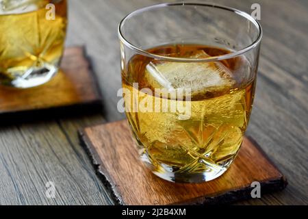 Nahaufnahme eines Glases Bourbon mit großem Eiswürfel Stockfoto