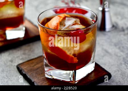 Altmodischer Cocktail mit Orangenschalen-Garnitur und Maraschino-Kirsche Stockfoto