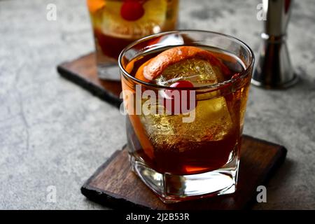 Altmodischer Cocktail mit Orangenschalen-Garnitur und Maraschino-Kirsche Stockfoto