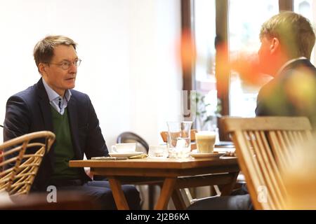 Köln, Deutschland. 31. März 2022. Bundesgesundheitsminister Karl Lauterbach (l, SPD) sitzt in seinem Stammcafe in Köln. Quelle: Oliver Berg/dpa/Alamy Live News Stockfoto