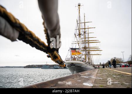 Kiel, Deutschland. 31. März 2022. Das Segelschulschiff 'Gorch Fock' liegt auf einem Kai am Marinestützpunkt. Nach acht Jahren hat Kapitän See Brandt das Kommando über das Segelschulschiff „Gorch Fock“ an Kapitän See Graf von Kielmansegg übergeben. Quelle: Daniel Reinhardt/dpa/Alamy Live News Stockfoto