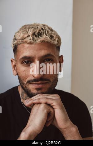 Porträt eines jungen Mannes mit der Hand am Kinn im Studio Stockfoto