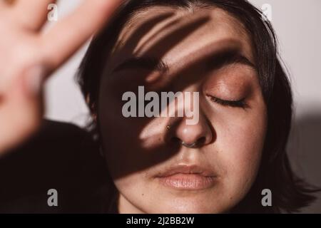 Junge Frau mit geschlossenen Augen im Studio Stockfoto