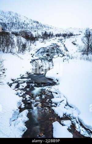 Wasserfall auf dem Fluss Ersfjordelva im Winter, Ersfjordbotn, Troms, Norwegen, vertikal, In der Nähe der Stadt Tromso Stockfoto