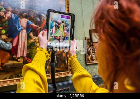 London, Großbritannien. 31. März 2022. Die Mitarbeiter der Galerie testen das System, indem sie mit Hilfe von animierten „Keepers“ – dem „Keeper of Paintings“ und der „Palette of Perception“-Familienspur-App in der National Gallery – nach Informationen suchen und Juwelen sammeln, während sie ihre erste immersive Augmented Reality-App startet, die mit Hilfe von Over erstellt wurde 70 Kinder rechtzeitig zu den Osterferien. Es handelt sich um eine kostenlose mobile Erfahrung, die AR-Technologie nutzt und Kinder dazu ermutigt, die Galerie zu erkunden und mehr über ihre Gemälde zu erfahren. Kredit: Guy Bell/Alamy Live Nachrichten Stockfoto