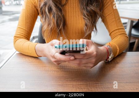 Detail der Hand einer Person hält und mit einem modernen Handy, um Nachricht zu senden, Kommunikation mit modernen technologischen Gadget, Arbeit und Lebensstil Stockfoto