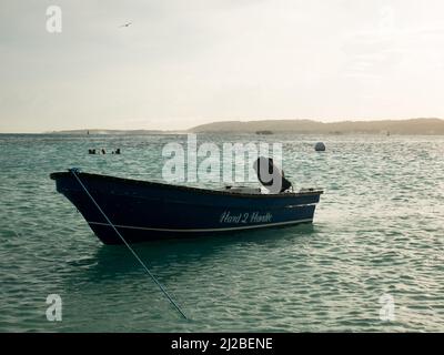 San Andrés, Kolumbien - November 18 2021: Blaues Boot mit Motor an Shore gebunden mit Türkisboden bei Sonnenuntergang Stockfoto