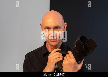 London, Großbritannien. 31. März 2022. Der Fotograf Ray Burmiston posiert in seiner Ausstellung ‘Art of London Presents Take A Moment 2022’, die in einer temporären Galerie unter den Leinwänden des Piccadilly Circus zu sehen ist. Über hundert Stars Der A-Liste, die von dem NHS-Arzt und TV-Moderator Ranj Singh ins Leben gerufen wurden, wurden von Burmiston fotografiert und schlossen ihre Augen vor der Kamera, um zu pausieren, zu reflektieren und das Bewusstsein für psychische Gesundheit zu schärfen. Kredit: Stephen Chung / Alamy Live Nachrichten Stockfoto