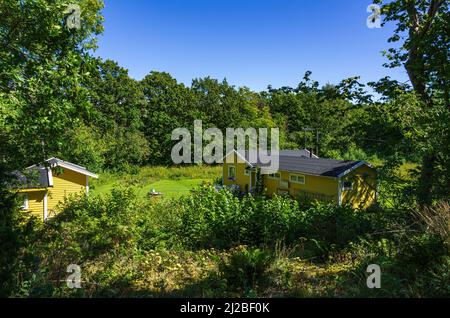 Idyllisches Anwesen mit kleinen Hütten in der grünen Natur, Südkoster-Insel, Bohuslän, Västra Götalands län, Schweden. Stockfoto